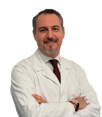 Il Dott. Edoardo Brauner del Coppedè Medical Hub di Roma, un uomo con capelli corti e scuri e pizzetto grigio, sorride in camice bianco e cravatta rossa, incrociando le braccia su uno sfondo bianco.