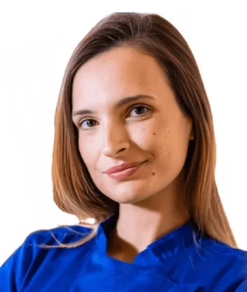 La Dott.ssa Roberta Carlini Coppedè è ritratta con capelli lisci e castani, indossa un top blu royal e sorride dolcemente. Ha un segno di bellezza sulla guancia ed è in posa su un semplice sfondo bianco presso il Medical Hub di Roma.